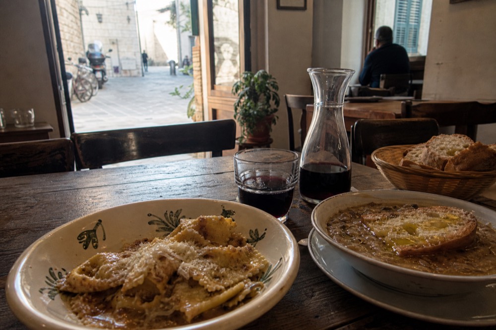 Fresh pasta and Tuscan dishes plated on a wooden restaurant table
