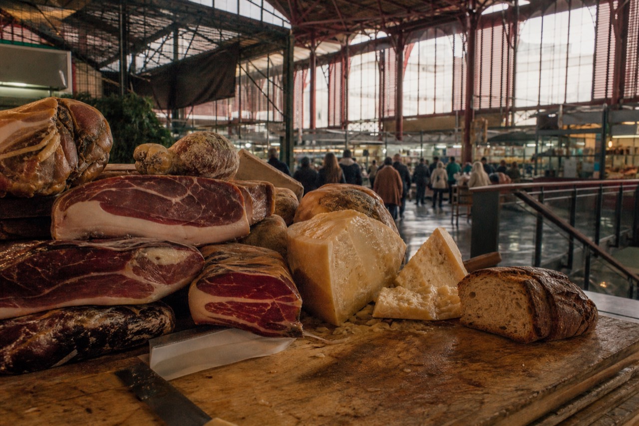 Counter of a Florence food market with cured meats, bread and cheese on display
