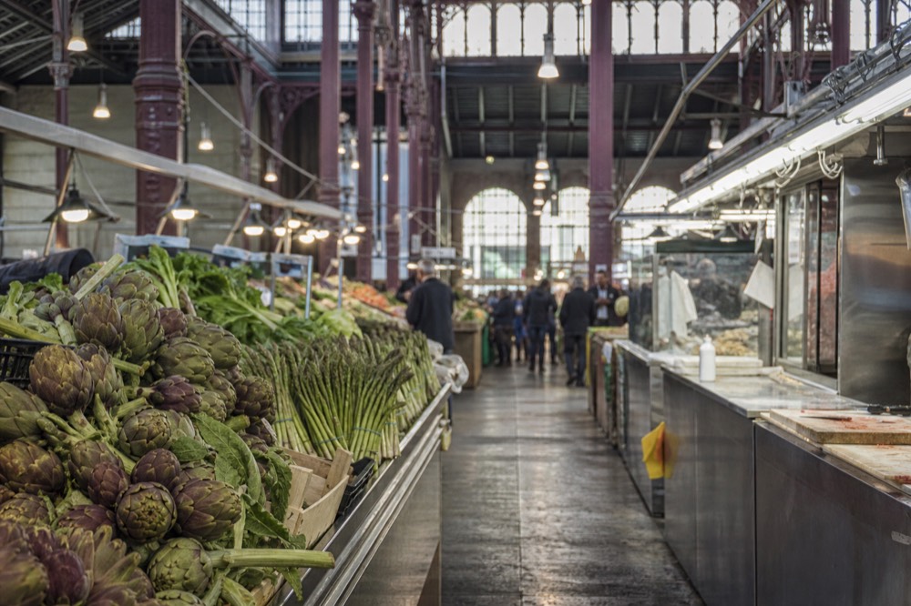 A covered Florence food market hall with stalls and hanging lamps