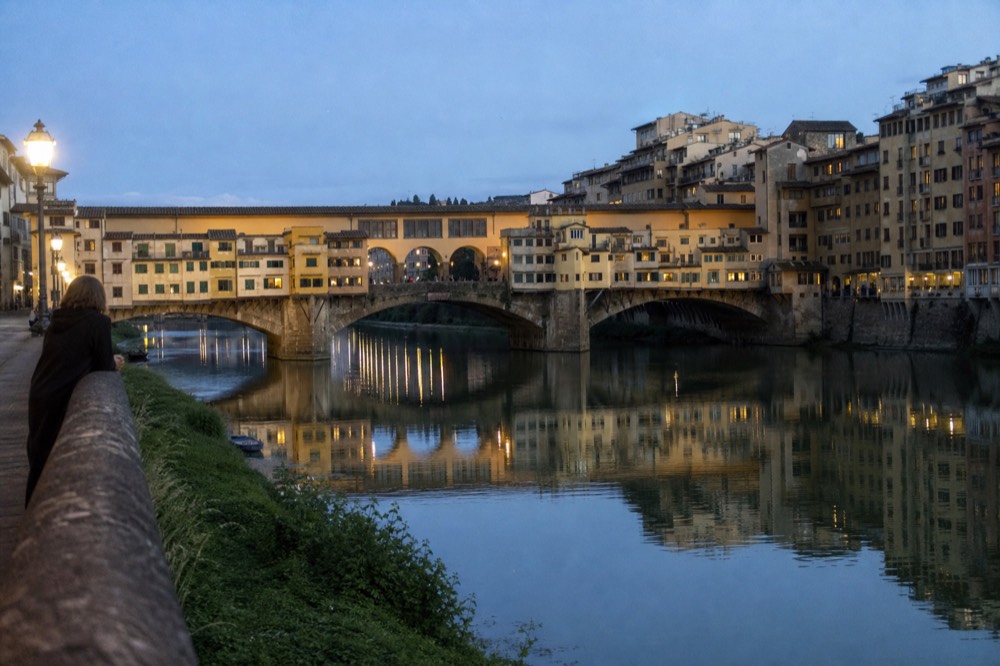 The Arno river and Ponte Vecchio at dusk with warm light on the water