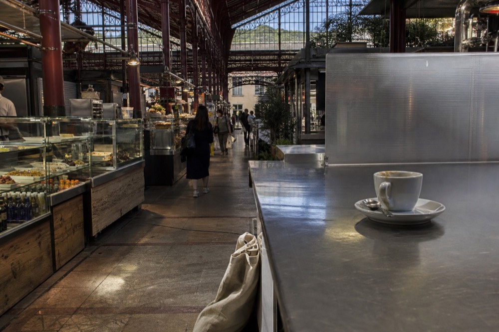 Interior of a Florence market hall with food stalls under a cast iron and glass roof