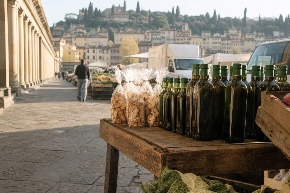 Bottles of olive oil and packs of biscotti arranged on a wooden market stall