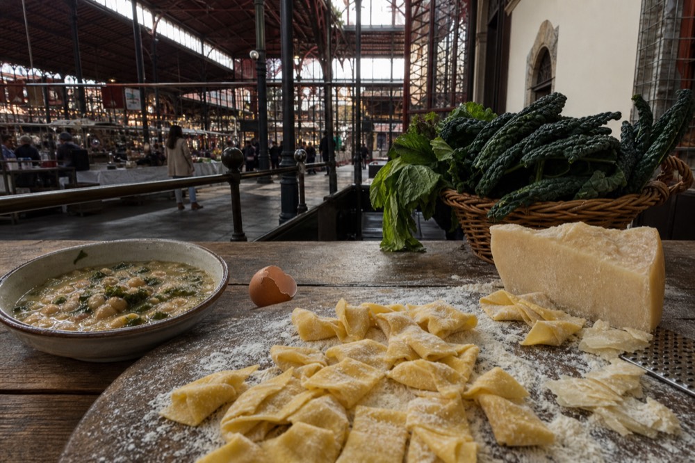 Fresh pasta and Tuscan dishes laid out on a wooden table