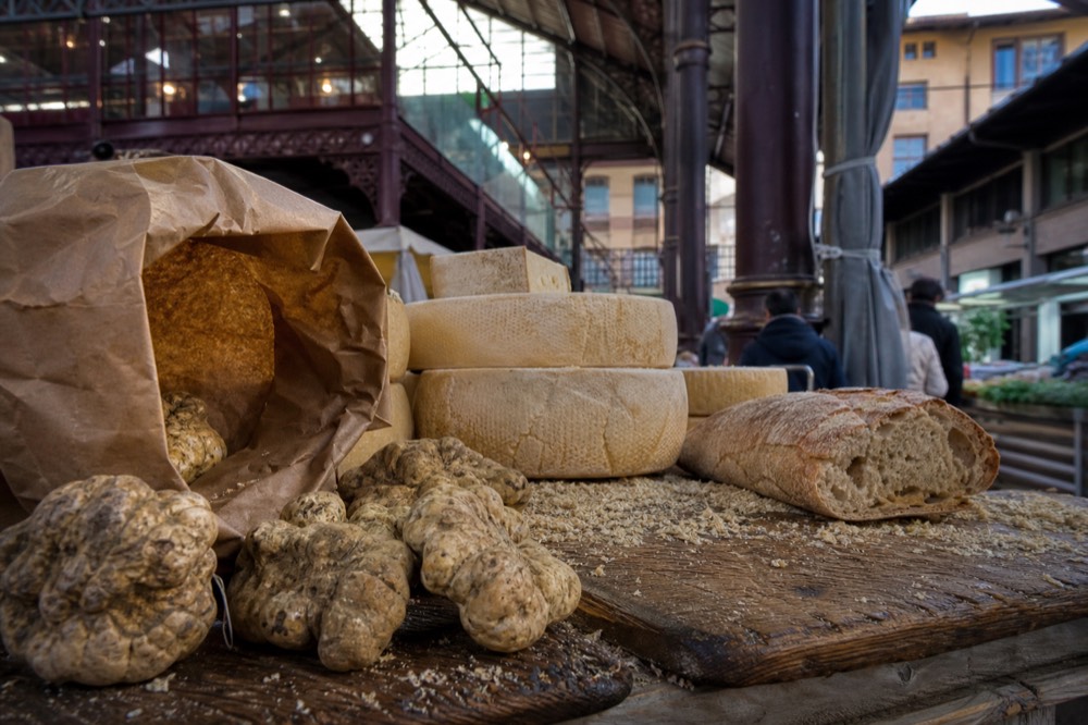 Florence market stall with truffles, cheese and bread on a wooden counter