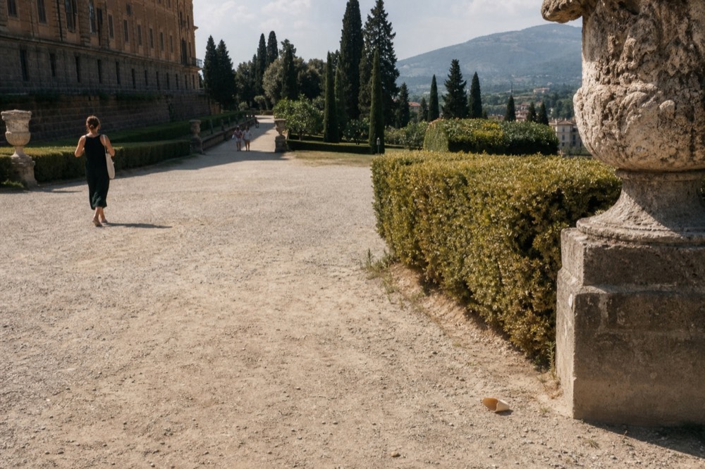 Boboli Gardens with a wide gravel path, cypress trees, and a view of the Tuscan hills