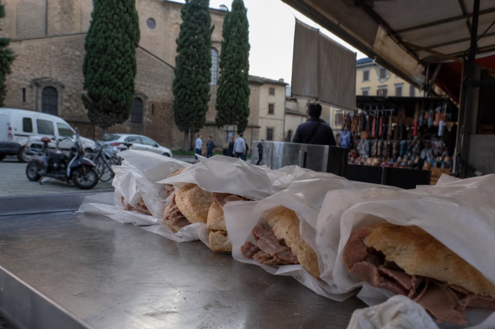 Fresh lampredotto sandwiches wrapped in paper on a market stall counter