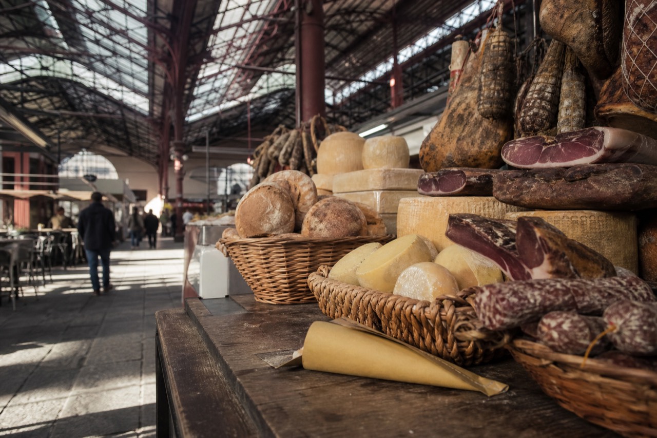 Baskets of bread, cheese and cured meats on a wooden market counter in Florence