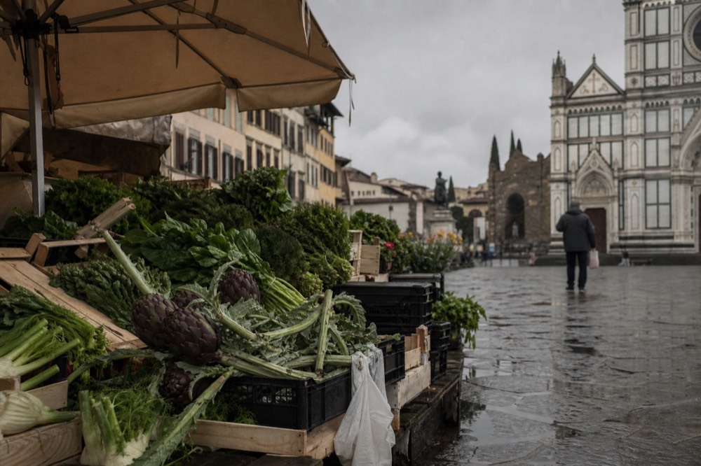 Spring market stall with fresh artichokes and green vegetables