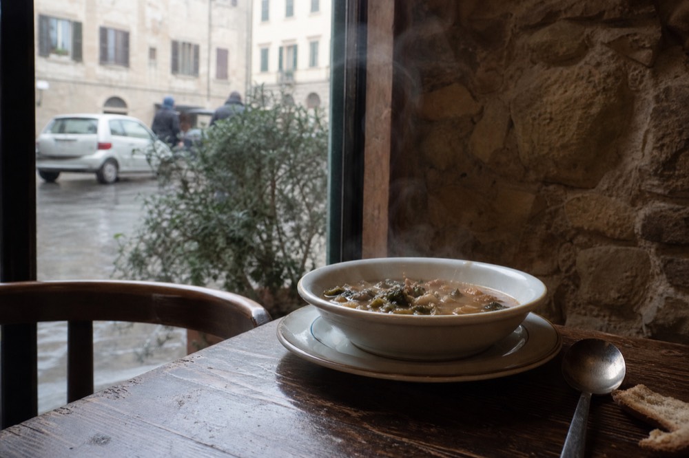 Steaming bowl of ribollita soup on a trattoria table