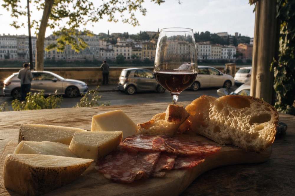 Tuscan cheese and cured meat platter with pecorino, salami and bread on a wooden board