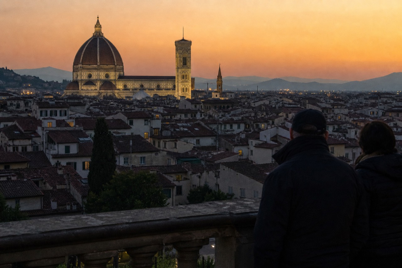 Floodlit Florence skyline at dusk with the Duomo dome and bell tower against an orange sky