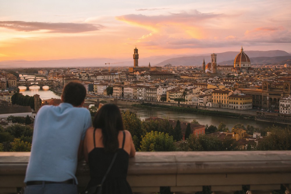 The Florence skyline at sunset seen from a terrace above rooftops