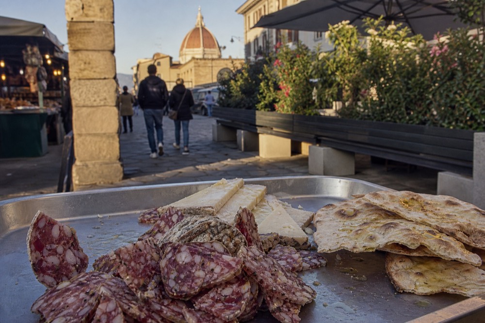 A tray of Tuscan cured meats, cheese and bread on a deli counter