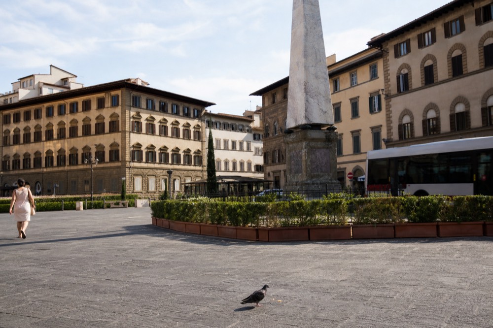 A Florence square with an obelisk and historic buildings at midday