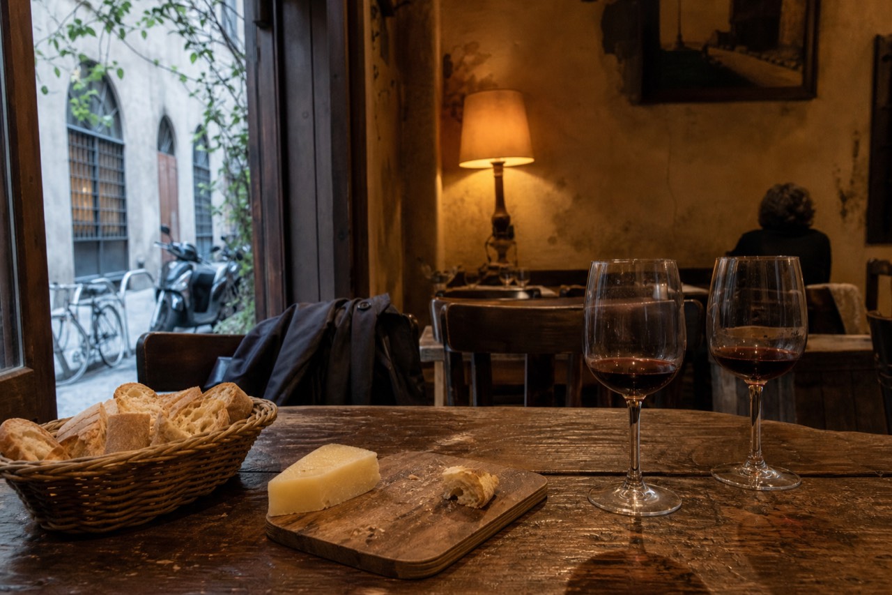 A table set with Tuscan bread, cheese and two glasses of red wine in a Florentine trattoria