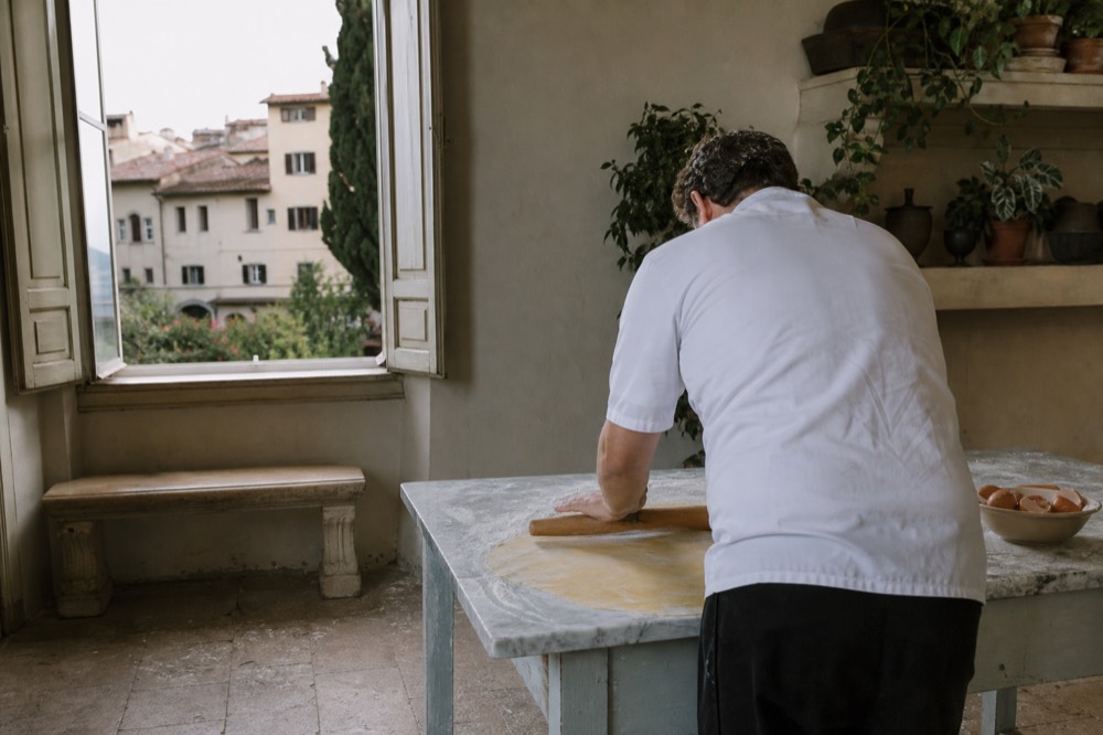 A chef demonstrating pasta-making in a Florence cooking school kitchen