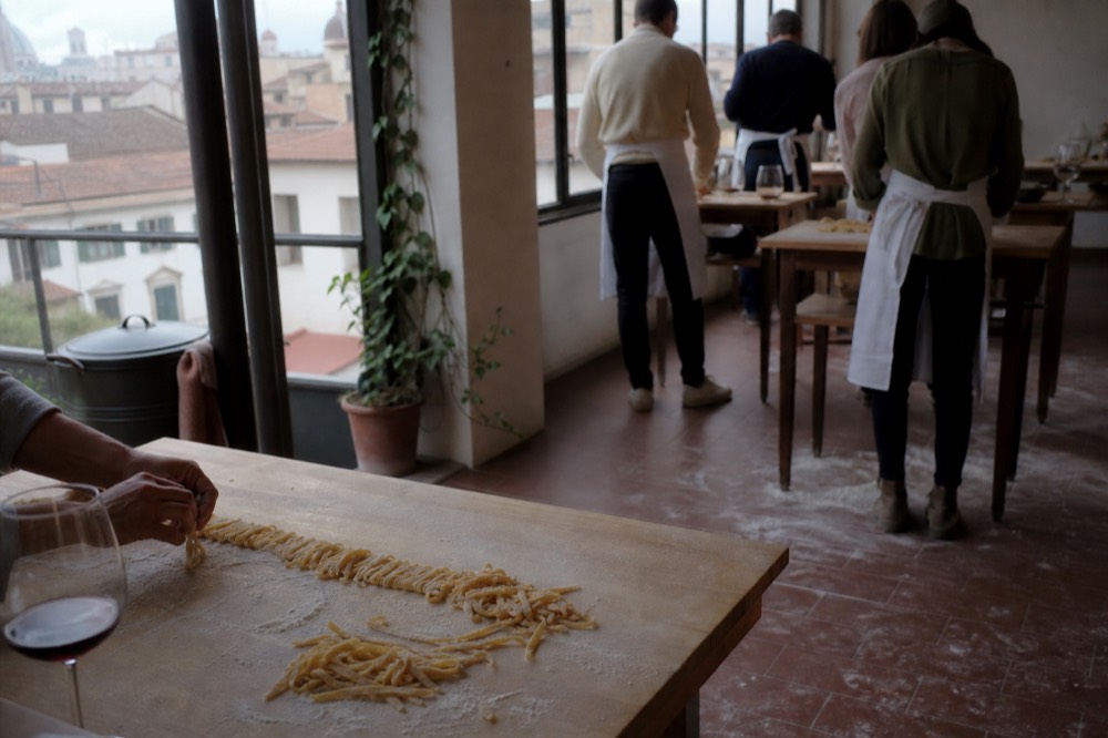 Fresh pasta being made by hand on a wooden table in a Florence cooking class