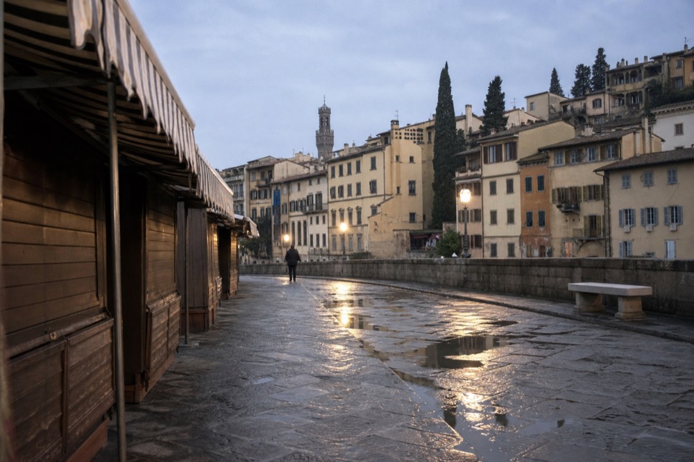 Market square outside a historic building with striped awnings over closed stalls
