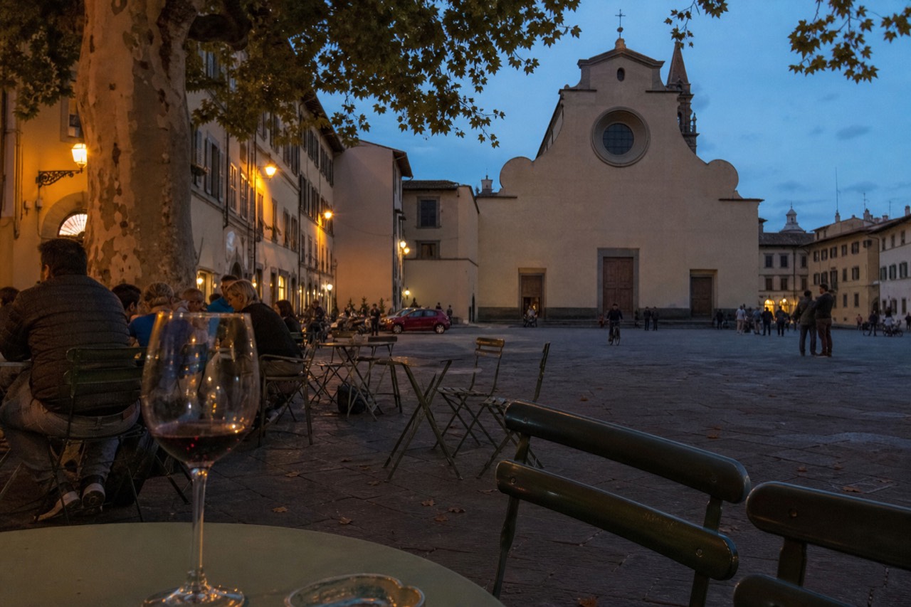 Evening tables and facades around a quiet Oltrarno square in Florence